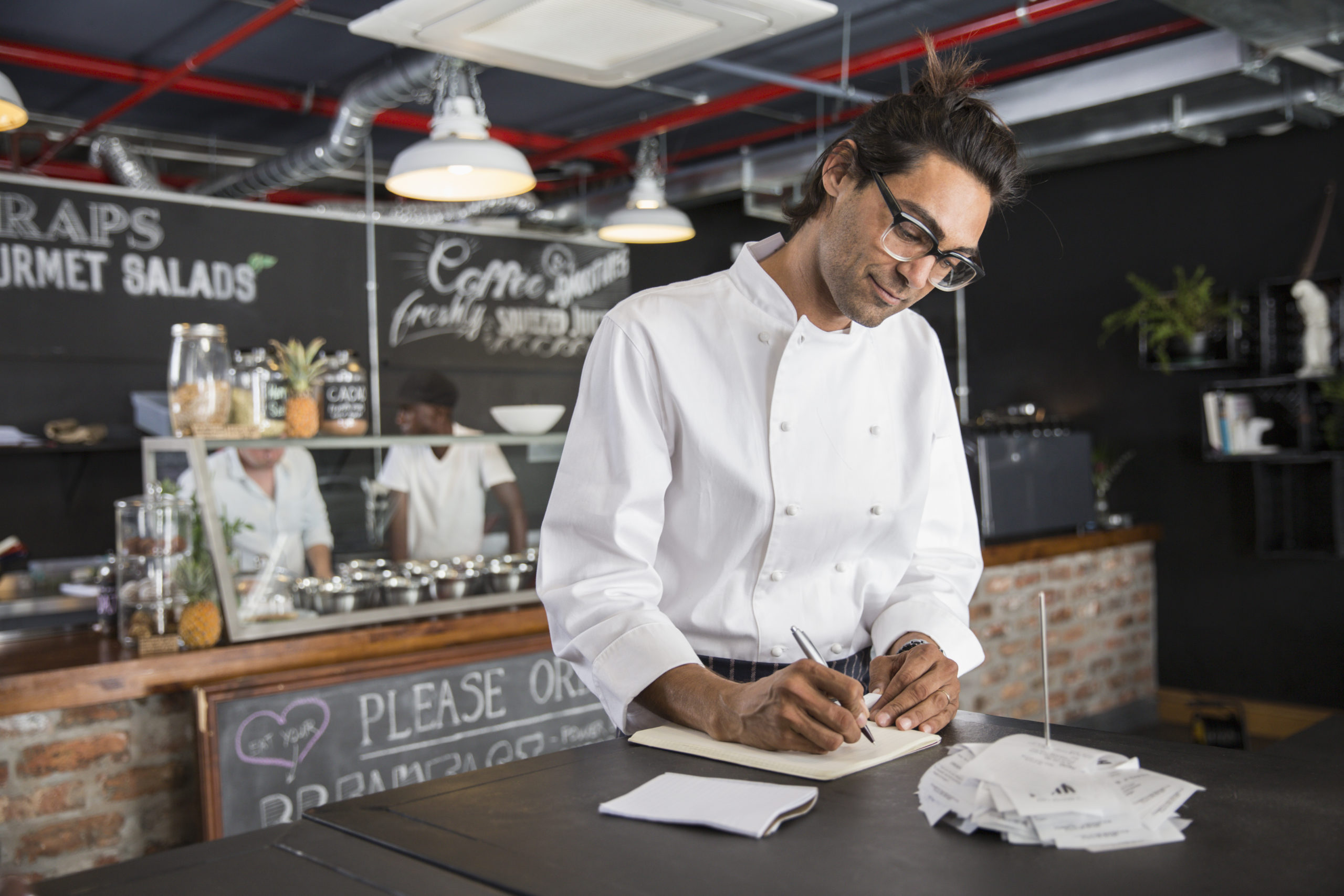 Chef In Restaurant Writing In Notepad - Recuperação de Impostos | Planrec Gestão Tributária